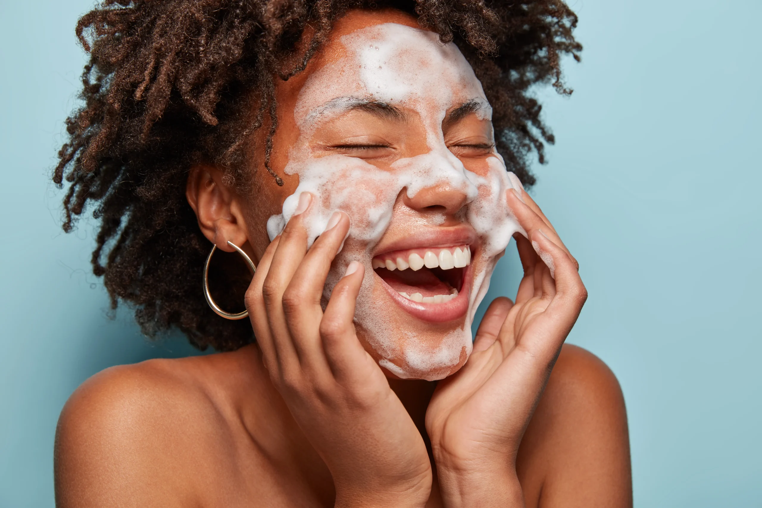 portrait young woman with afro haircut washing her skin scaled